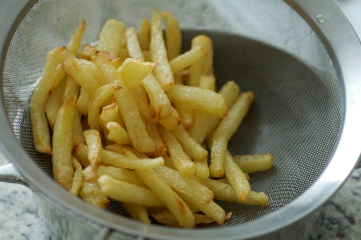 É importante escorrer na peneira assim que tirar do óleo. 